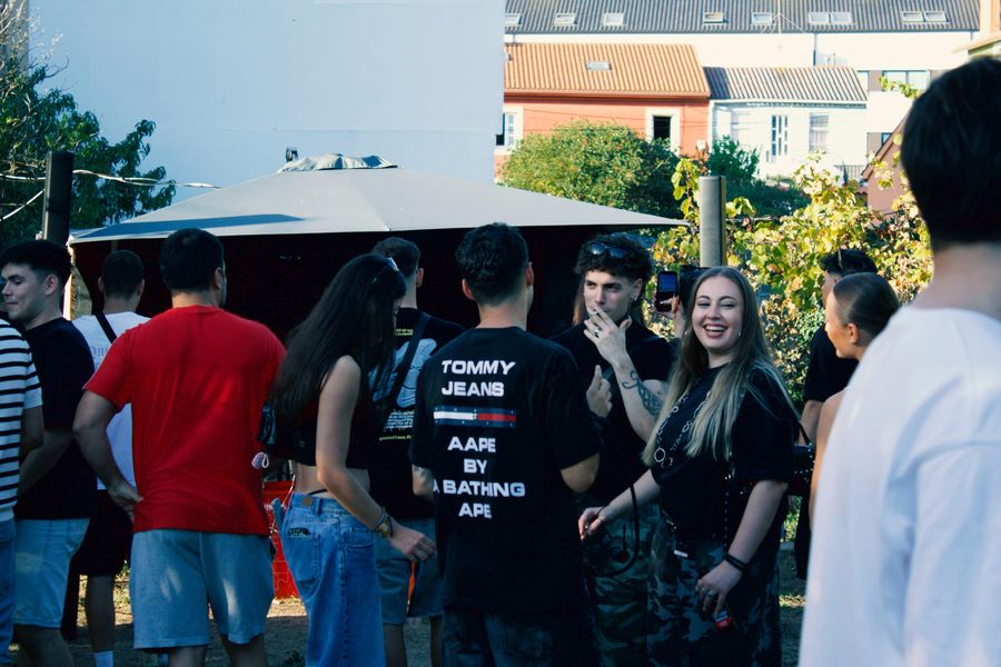 Público junto a la carpa, al sol.